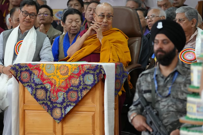 An Indian security officer stands watch as Tibetan spiritual leader the Dalai Lama is seated on stage with Indian officials during celebrations on the 90th birthday of the Dalai Lama at the Main Temple in Dharamsala, India, July 6, 2025.