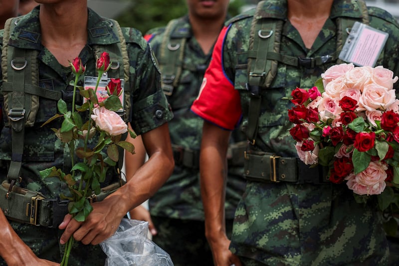Thai soldiers hold flowers received from supporters at army headquarters in Bangkok, July 29, 2025.
